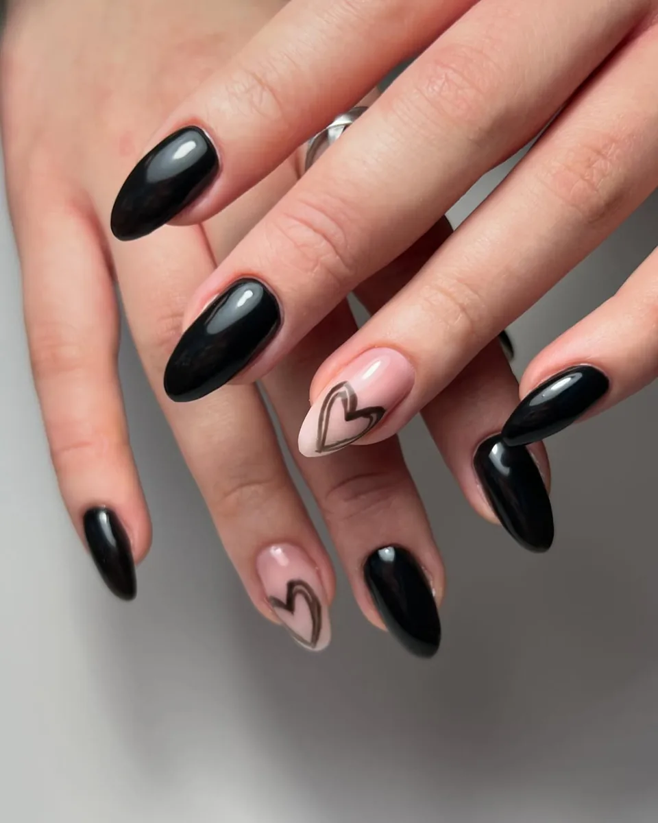 Glossy black almond nails with two heart-outline accents